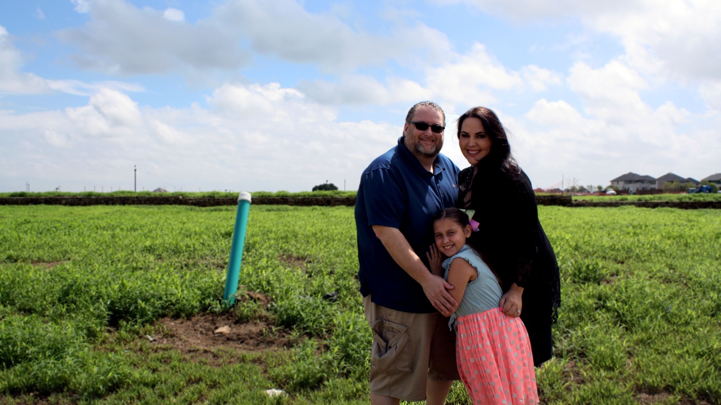 Scott, Marie and Alexandra Bailey standing on the plot where their house is being built in Prosper at the Windsong Ranch planned community (before construction began).